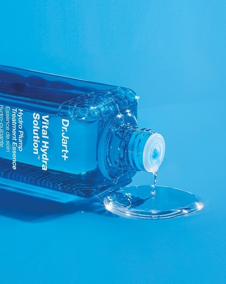 A bottle of Vital Hydra Solution Essence gently pours liquid essence.